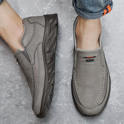 Top and side view of grey slip-on leather shoes for men on concrete floor