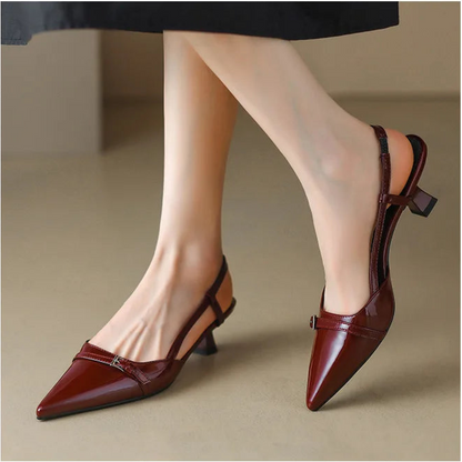 Wine red patent pointed-toe slingback heels worn with skirt, side view