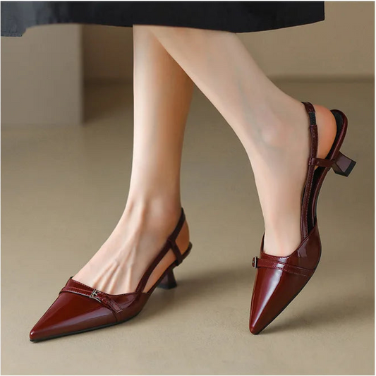 Wine red patent pointed-toe slingback heels worn with skirt, side view