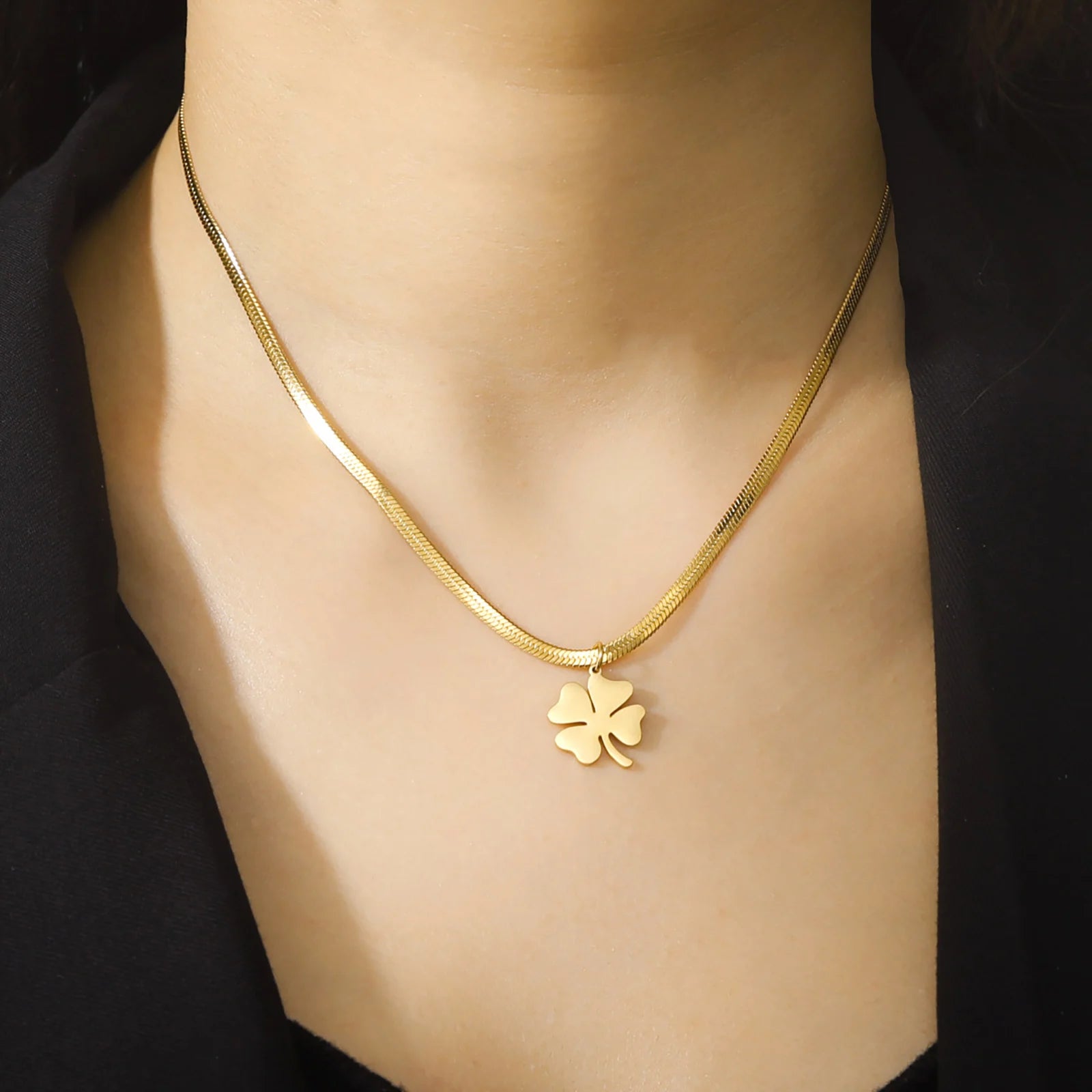 old clover pendant necklace worn with black blouse, natural light